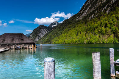 Wooden posts in lake against sky