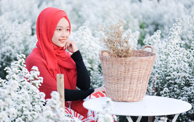 Portrait of woman with red flowers in basket