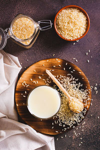 Alternative healthy rice milk in a glass and rice cereal on the table top and vertical view