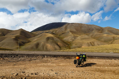 Man riding motorcycle on mountain against sky