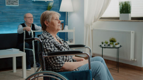 Senior woman looking away while sitting on wheelchair