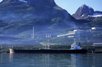 Sailboats in sea against mountains