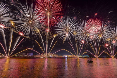 Firework display over river at night