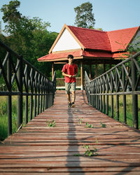 Rear view of woman walking on footbridge