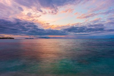 Scenic view of sea against dramatic sky during sunset