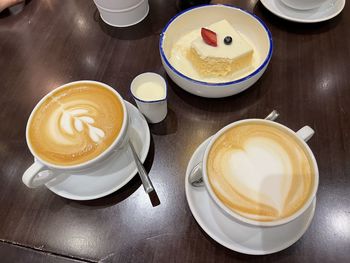High angle view of cappuccino and coffee on table