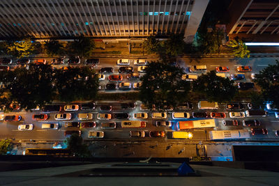 High angle view of cars moving on road by buildings at night