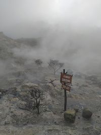 Information sign on land during foggy weather