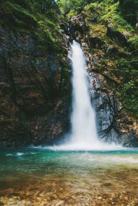 Scenic view of waterfall against sky