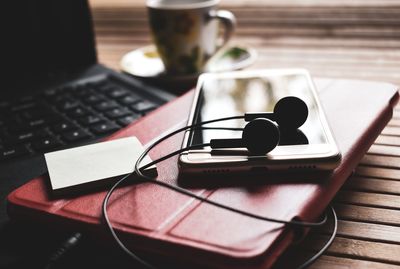 Coffee cup and laptop on table