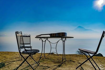 Lifeguard chair by sea against clear blue sky