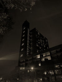 Low angle view of illuminated buildings against sky at night