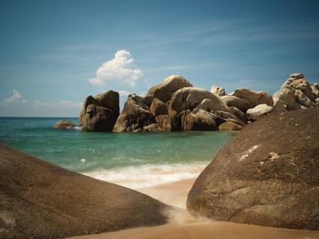 Rocks on beach against sky