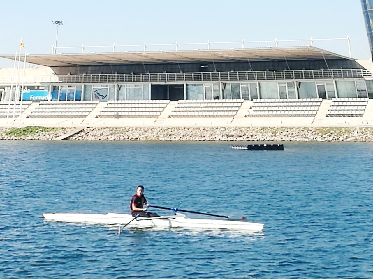 MAN IN BOAT AT SEA AGAINST CLEAR SKY