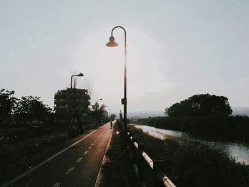 Street amidst trees against sky in city