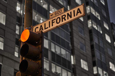 Low angle view of signboard on stoplight against building