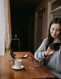 Portrait of young woman sitting on table