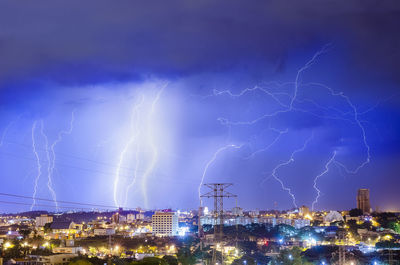 Lightning over illuminated buildings in city at night