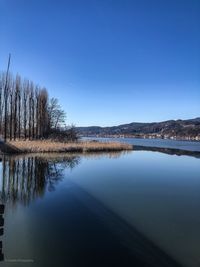 Scenic view of lake against clear blue sky