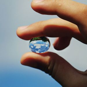 Close-up of human hand holding blue sky