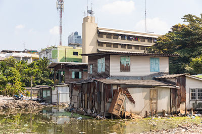 Buildings by river against sky