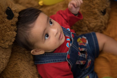 High angle view of cute baby girl sitting on teddy bear