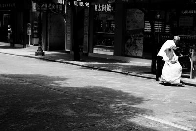 Full length of woman with umbrella in city