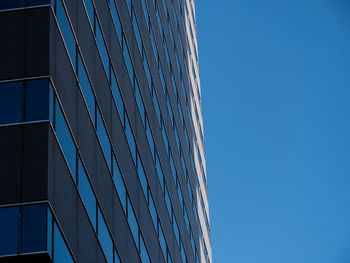 Low angle view of modern building against clear blue sky