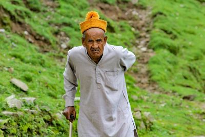 Portrait of senior man standing on field