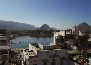 Udaipur, india view from a terrace on lake pichola surrounded with houses against mountains