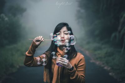 Portrait of young woman holding camera