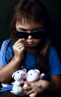 Close-up portrait of girl wearing sunglasses holding stuffed toys