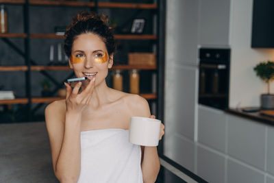 Young woman drinking coffee while sitting at home