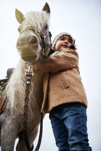 Happy little girl hugging pony