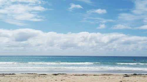 Scenic view of beach against cloudy sky