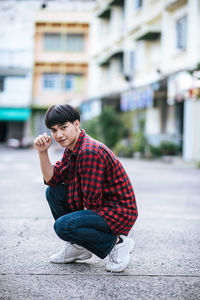 Portrait of woman sitting on street in city