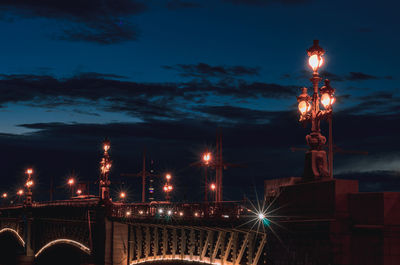 Illuminated bridge against sky at night