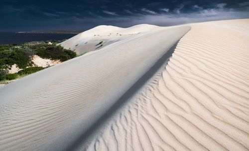 Sand dune in desert against sky