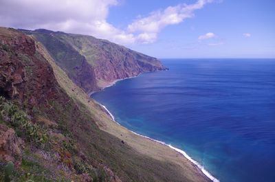 Scenic view of sea and mountains against sky