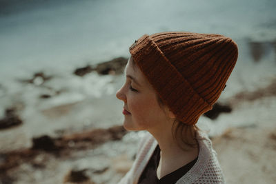 Close-up of woman in knit hat at beach