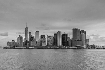 Modern buildings in city against cloudy sky