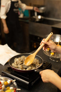 Midsection of person preparing food in kitchen