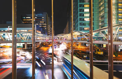 Light trails on street amidst buildings in city at night