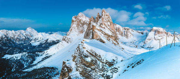 Scenic view of snowcapped mountains against blue sky