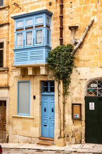 Typical maltese house with stone walls and window, wooden veranda