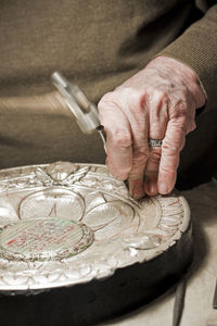 Midsection of man working on metallic plate