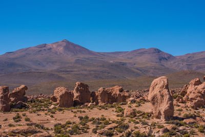 Scenic view of desert against clear blue sky