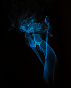 Close-up of blue light painting against black background