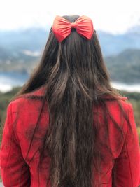 Rear view of woman standing against red umbrella