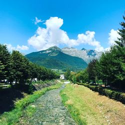 Road leading towards mountains against sky